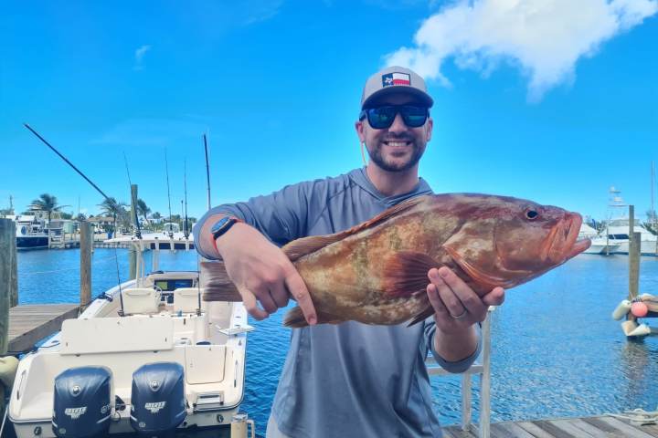 a man holding a fish on a boat