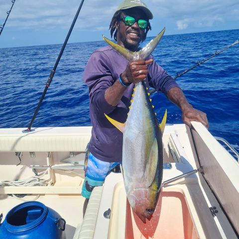 a person holding a fish on a boat in the water