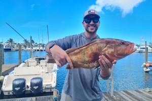 a man holding a fish on a boat