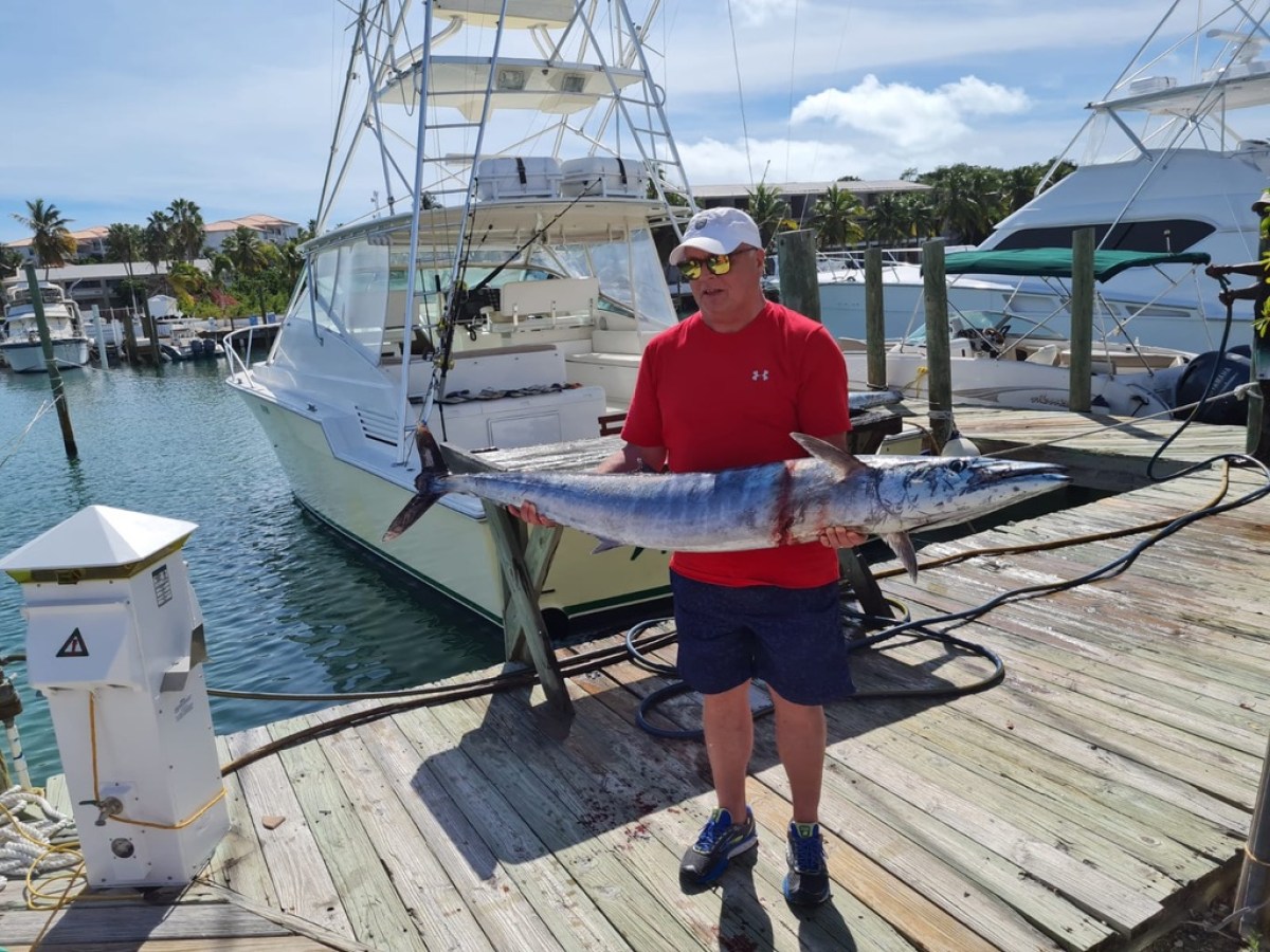 a man standing on a dock next to a body of water
