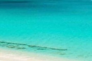 a sandy beach next to a body of water